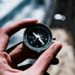 pexels-photo-12759623-12759623 Close-up of a hand holding a compass, symbolizing navigation and exploration outdoors.
