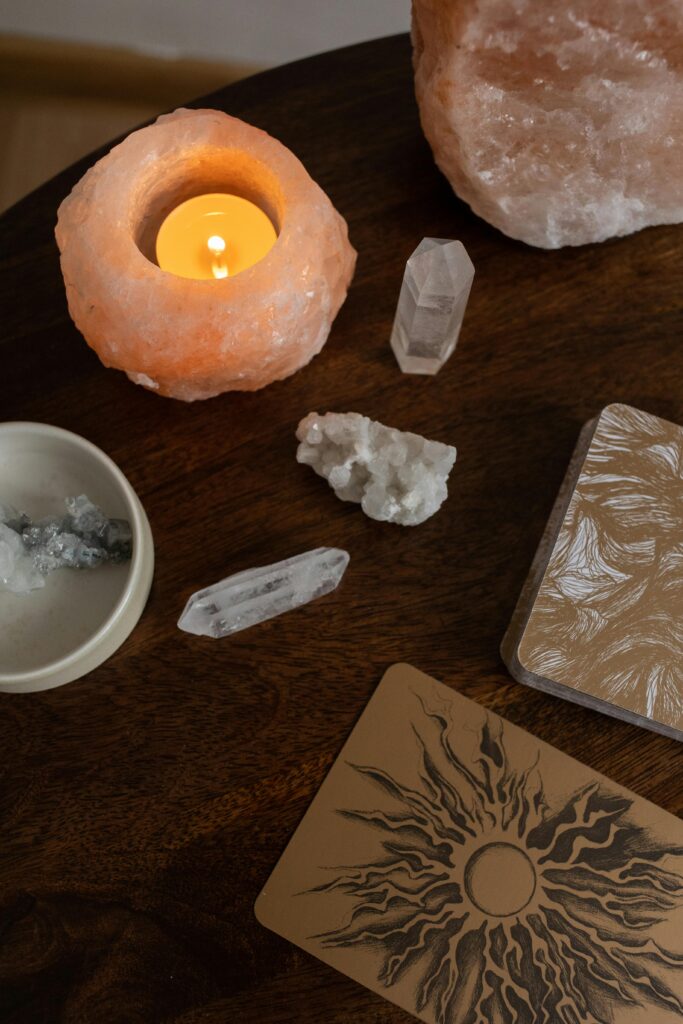 pexels-photo-6766514-6766514 A serene top view of crystals, a candle, and esoteric cards on a wooden table.