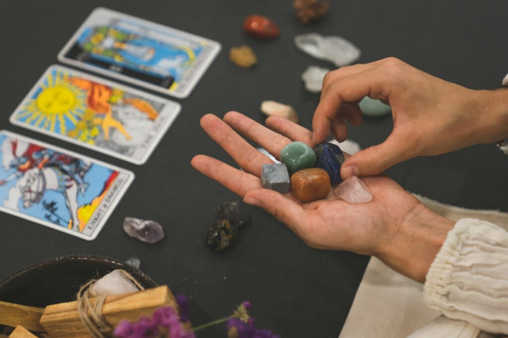 pexels-photo-8391232-8391232 Person holding healing crystals with tarot cards in the background, symbolizing spirituality.